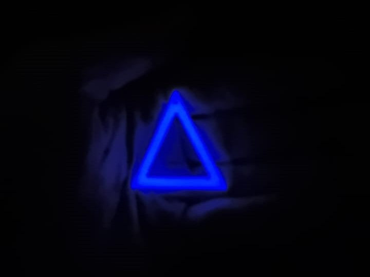 White to Purple Triangle Earring In hand glowing in the dark