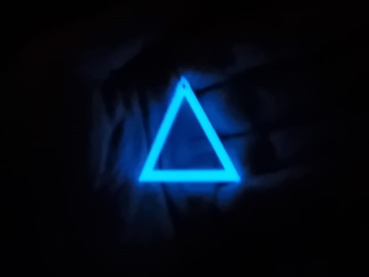 White to Blue Triangle earring In hand glowing in the dark