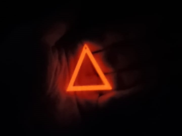 White to Dark Orange Triangle Earring In hand glowing in the dark