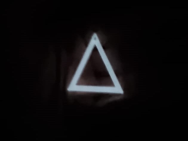 White to White Triangle Earring In hand glowing in the dark